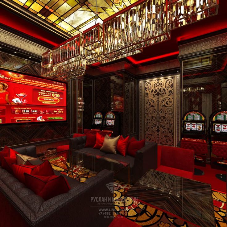 a room with red couches, chandelier and casino machines on the walls