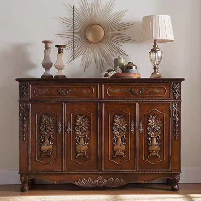 an ornately decorated sideboard with two lamps and a starburst above it