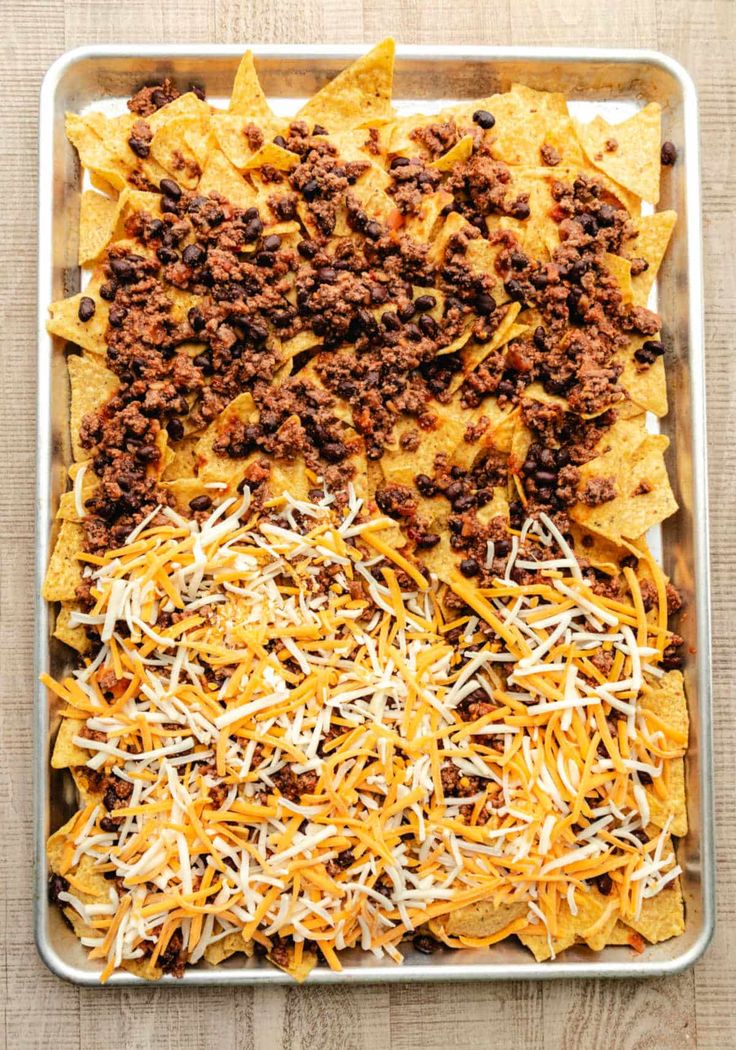 nachos with ground beef and cheese in a pan