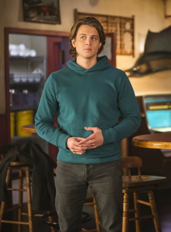 a young man standing in front of a table