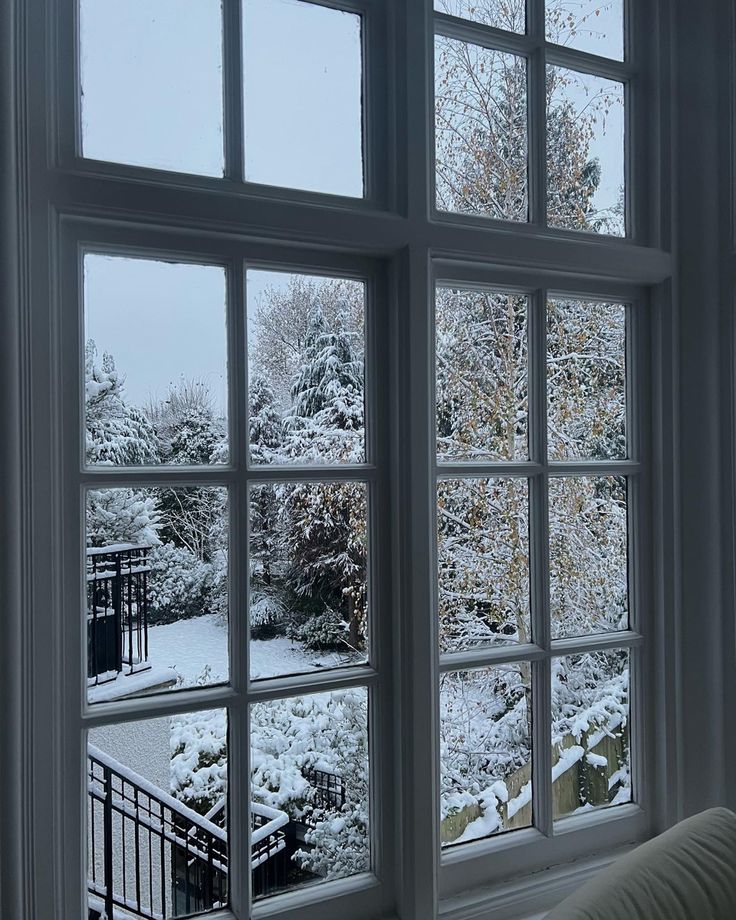 an open window with snow on the ground and trees in the backgrounge