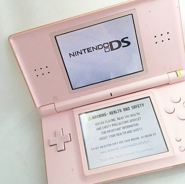 a pink nintendo ds game system sitting on top of a table