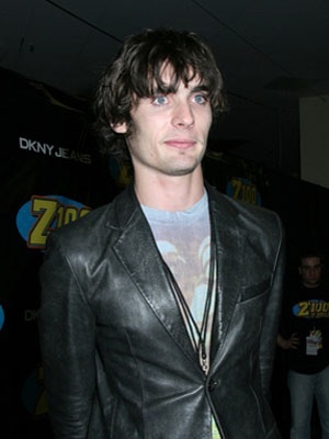 a man in a black leather jacket posing for the camera