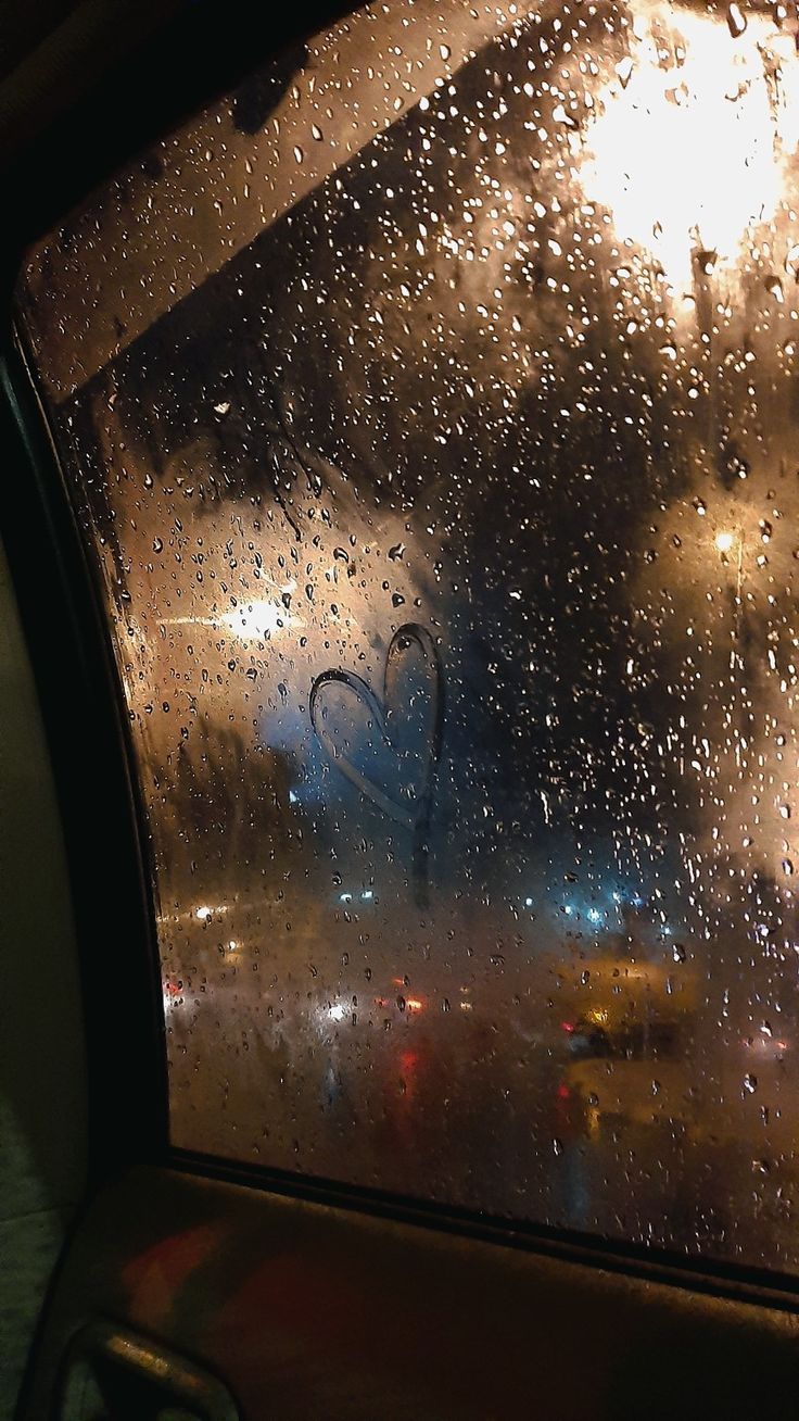 rain drops on the window of a car at night