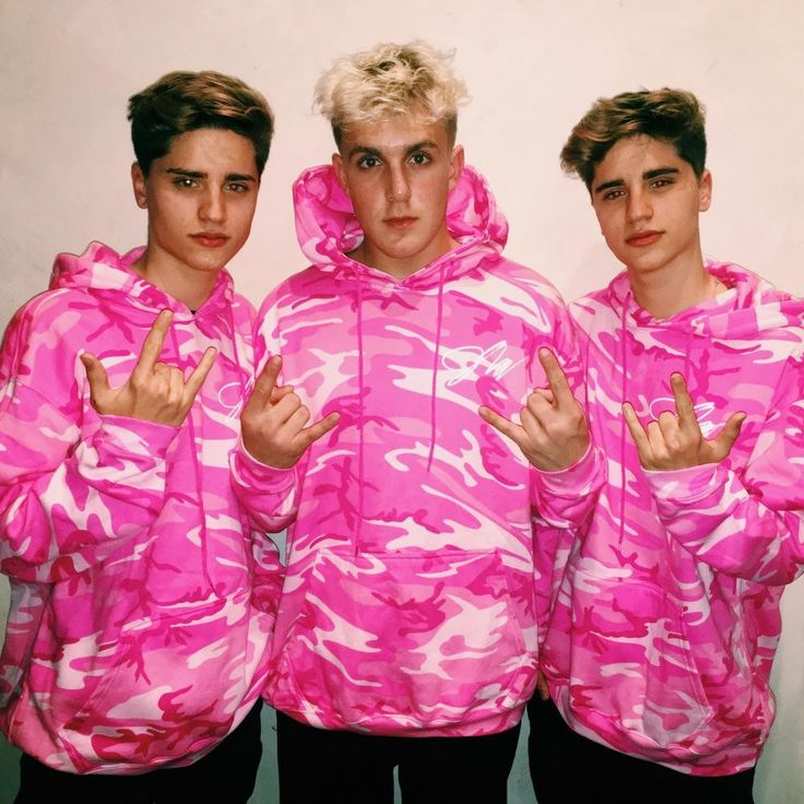 three young men in pink camo hoodies posing for the camera with their fingers up