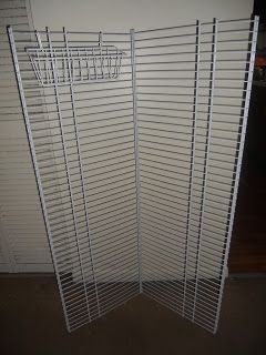 a white room divider sitting on top of a floor next to a door with shutters