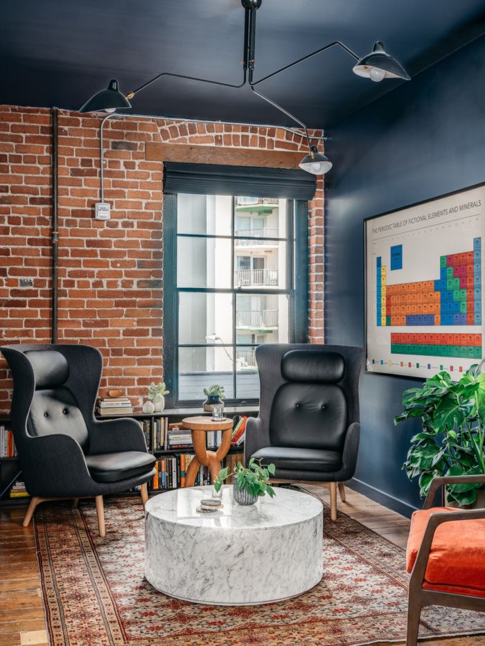 a living room filled with furniture and a brick wall