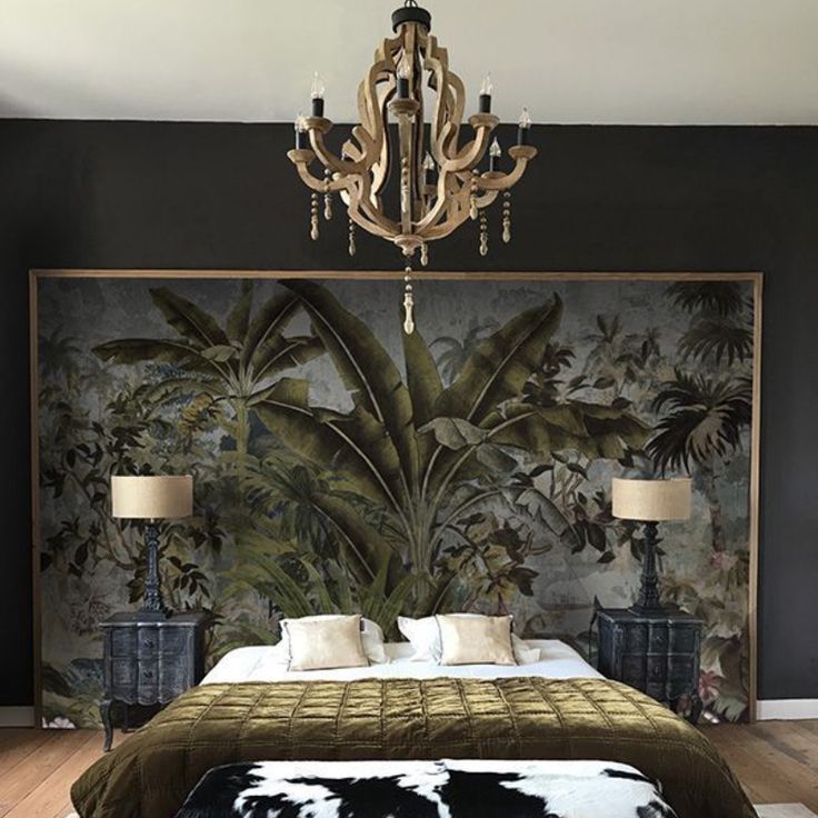 a bedroom with a bed, chandelier and paintings on the wall