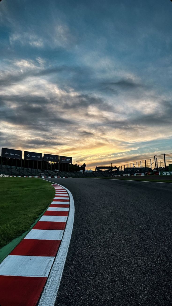 the sun is setting over an empty race track