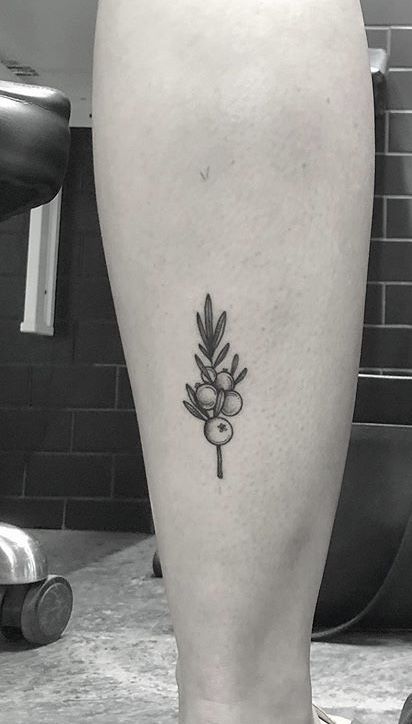 a black and white photo of a person's leg with a flower tattoo on it