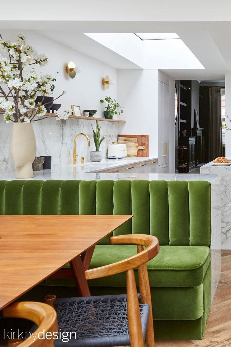 a green couch sitting next to a wooden table