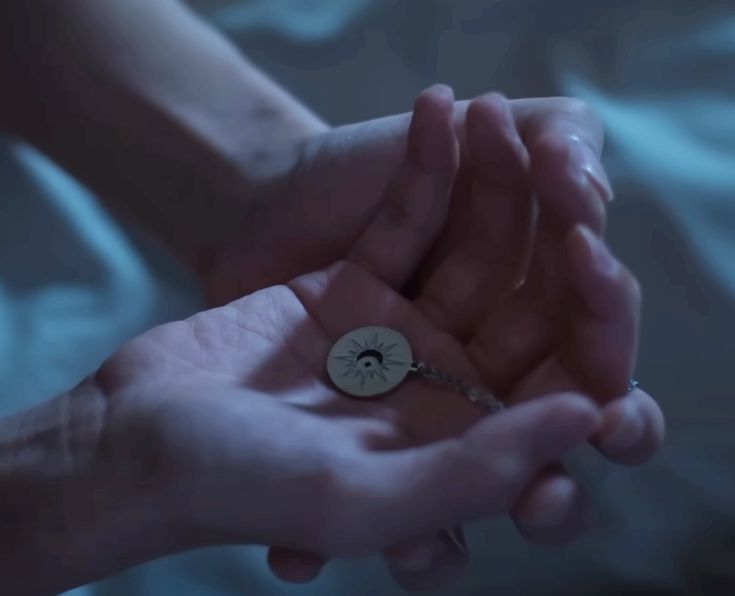 two people holding hands with a small clock on the middle of one hand and a key in the other