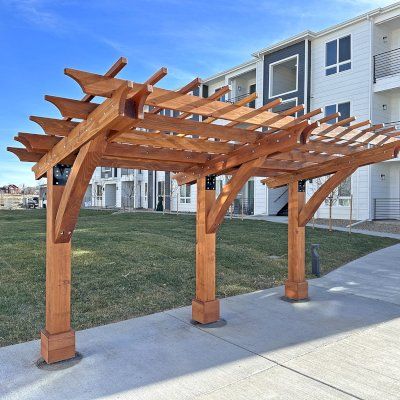 a wooden pergoline sitting on top of a sidewalk