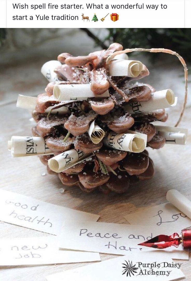 a pine cone with some writing on it sitting next to other paper and glue sticks