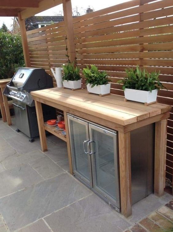 an outdoor grill with potted plants on top