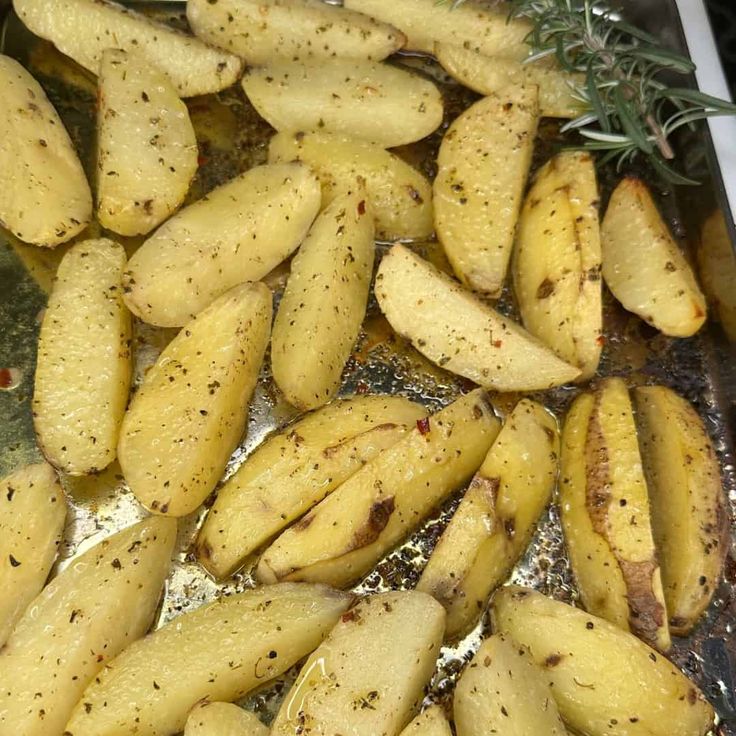 cooked potatoes in oil with rosemary sprigs on the side, ready to cook