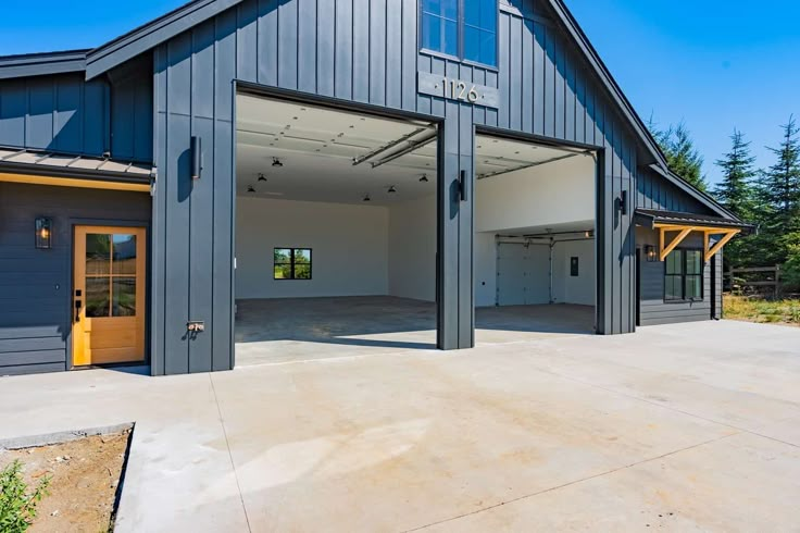 an empty garage with two doors open in front of it