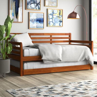 a living room with a couch, rug and pictures on the wall above it's headboard