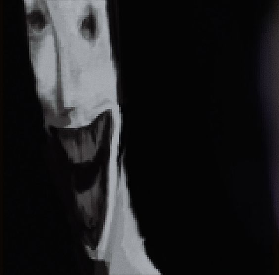 a creepy clown with his mouth open in the dark