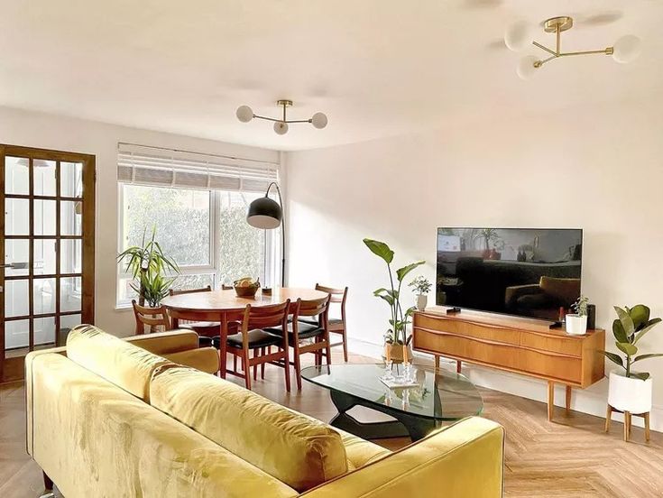 a living room filled with furniture and a flat screen tv on top of a wooden table