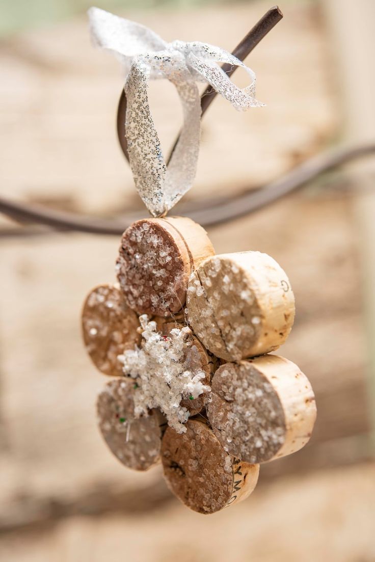 a bunch of wine corks are hanging from a string with some snow on them