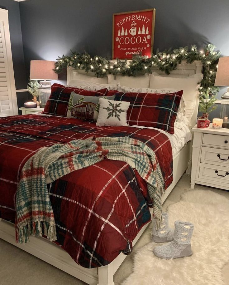 a bedroom decorated for christmas with red and green plaid bedding, white nightstands and lights