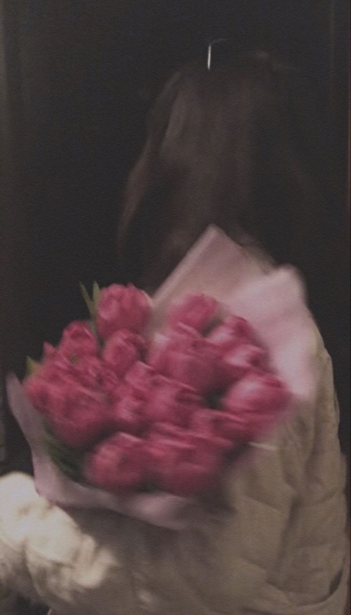 a person holding a bunch of pink flowers