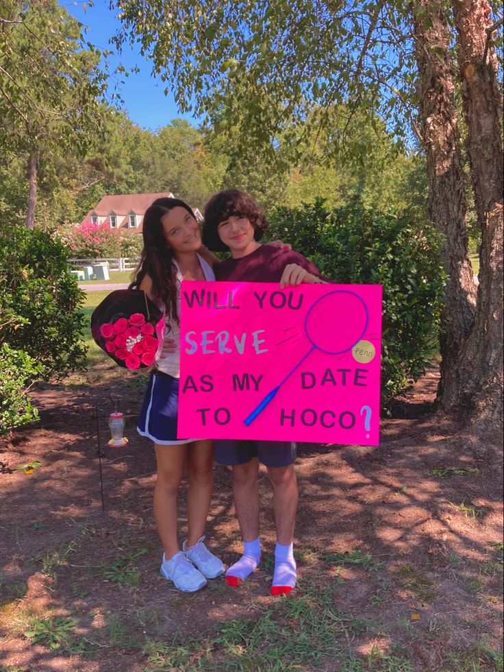 two girls holding up a sign that says, will you serve as my date to hoo?