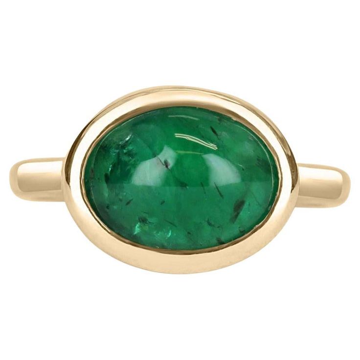 A bezel-set emerald cabochon ring in 14K yellow gold. Featured here is this lovely 4.77-carat natural, earth-mined, emerald cabochon. This stone displays a gorgeous, dark green color, and very good luster. This natural beauty is set in a 14K yellow gold bezel setting. Setting Style: Bezel / Solitaire set Setting Material: 14K Yellow Gold Gold Weight: 5.3 Grams Main Stone: Emerald Cabochon Shape: Oval Cut Weight: 4.77-Carats Clarity: Translucent Color: Dark Green Luster: Very Good Origin: Zambia Emerald Cabochon, Emerald Gem, Dark Green Color, Solitaire Setting, Colombian Emeralds, Cabochon Ring, Unisex Jewelry, Pinky Ring, Natural Earth