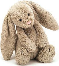 a gray stuffed rabbit sitting up against a white background