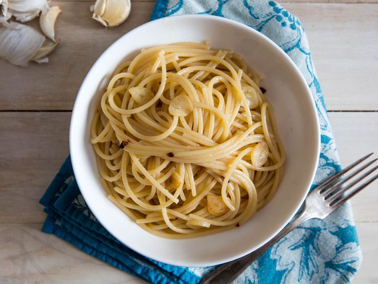 a white bowl filled with pasta on top of a wooden table