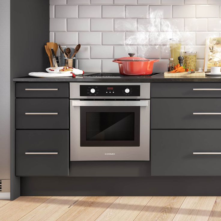 a stove top oven sitting inside of a kitchen next to a counter with pots and pans on it