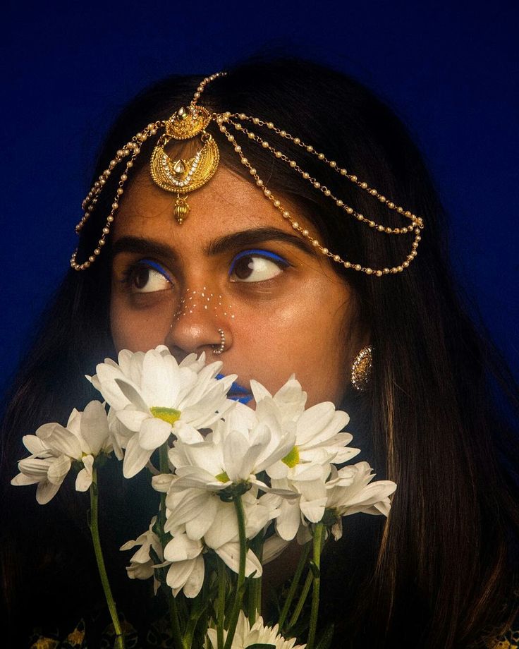 a woman is holding flowers in front of her face