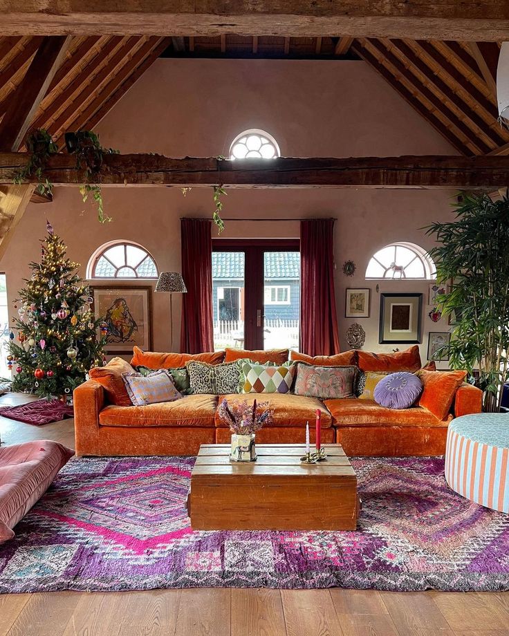 a living room filled with lots of furniture next to a christmas tree in the corner