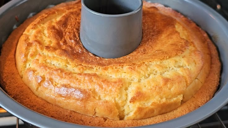 a bundt cake sitting on top of an oven rack with a cup in it