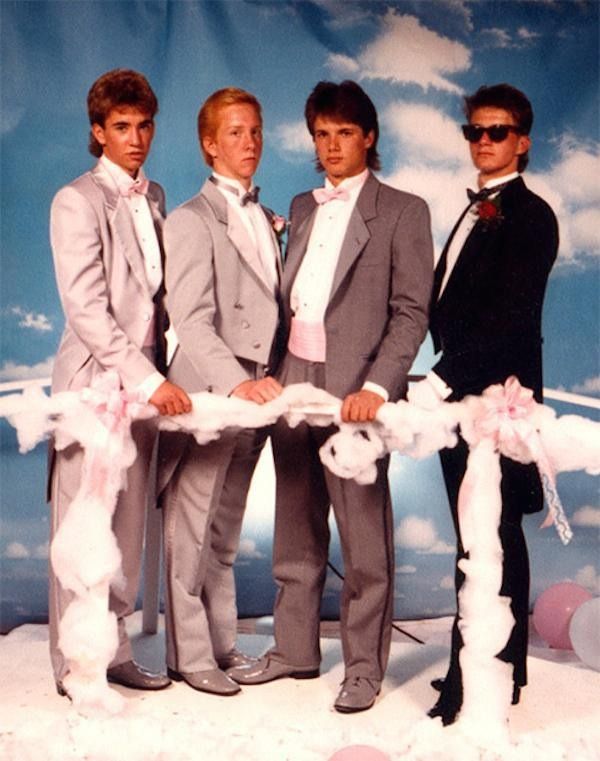 three young men in suits are holding a white ribbon at the end of a photo shoot