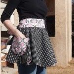 a woman wearing a black and white polka dot skirt with pink roses on the waist