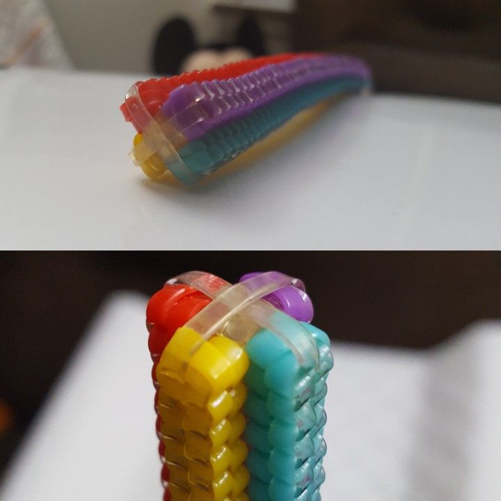 three different colored toothbrushes sitting next to each other on a white counter top