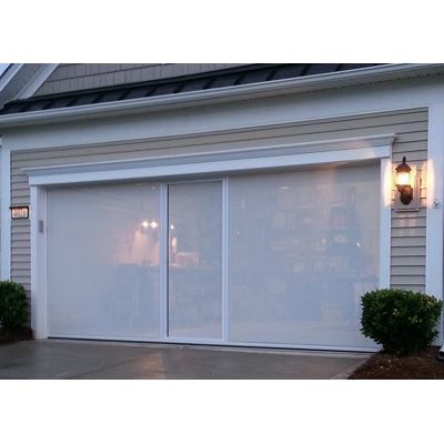 a white garage door is open in front of a house with two lights on it