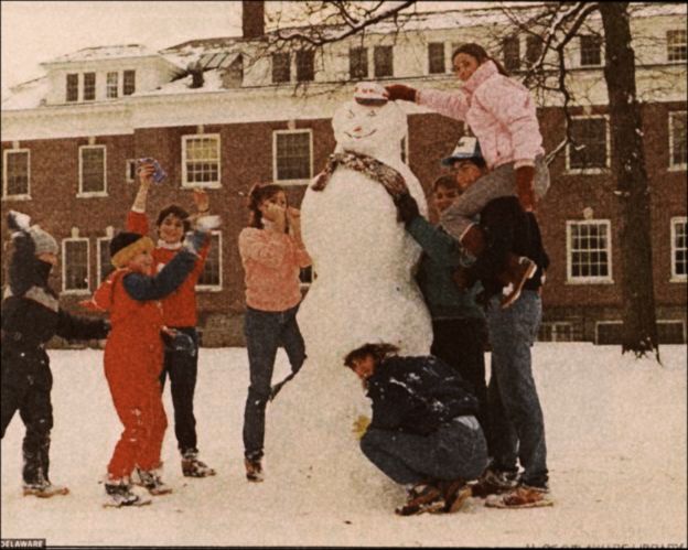 a group of people standing around a snowman