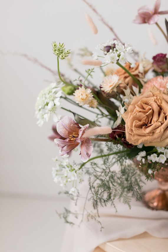 a vase filled with lots of flowers on top of a table