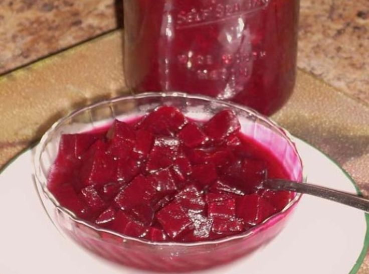 a glass bowl filled with cranberry sauce on top of a white plate