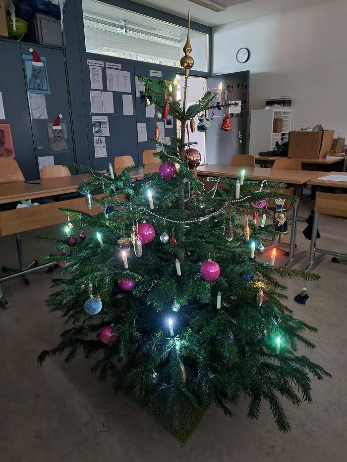 a decorated christmas tree in an empty classroom