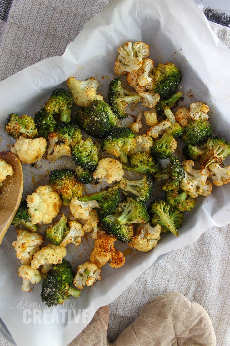 broccoli florets and cauliflower on a tray with a wooden spoon