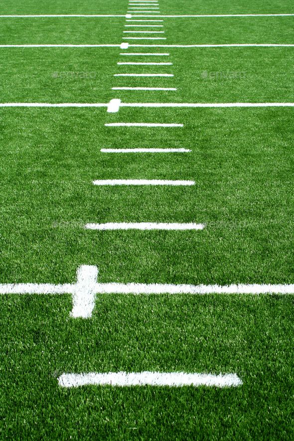 an empty football field with white lines on the grass and one line in the middle