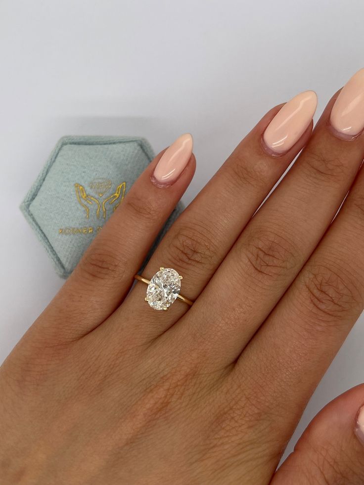 a close up of a person's hand with a ring on it and a diamond in the middle