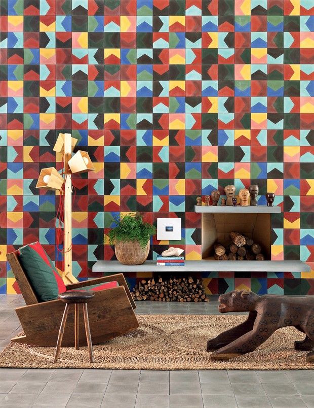 a living room with colorful tiles on the wall and furniture in front of it,