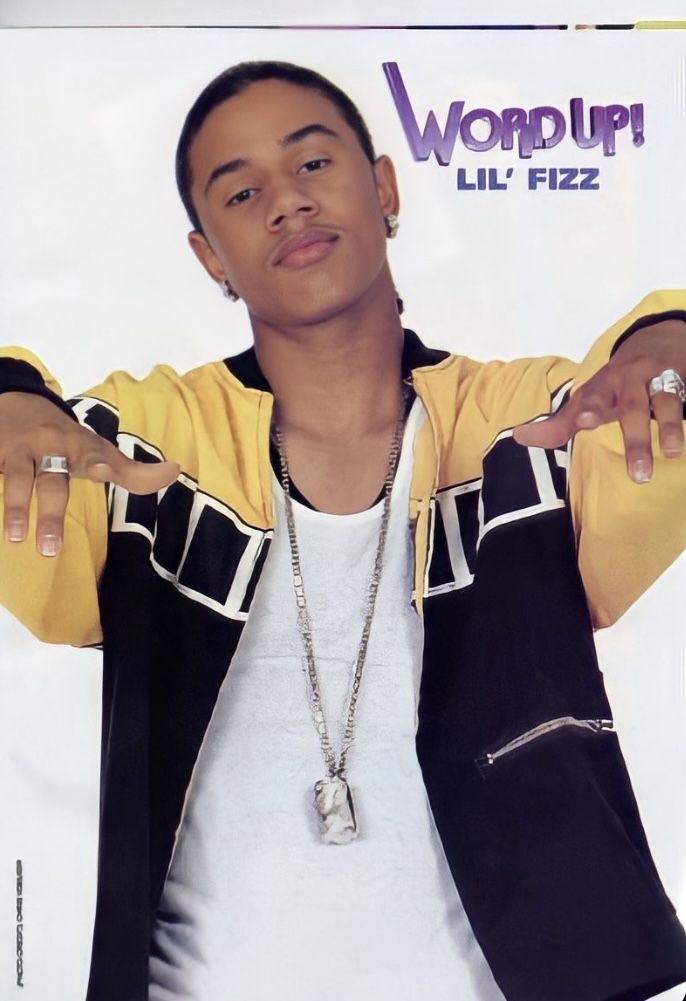 a young man wearing a yellow jacket and white t - shirt is posing for the camera