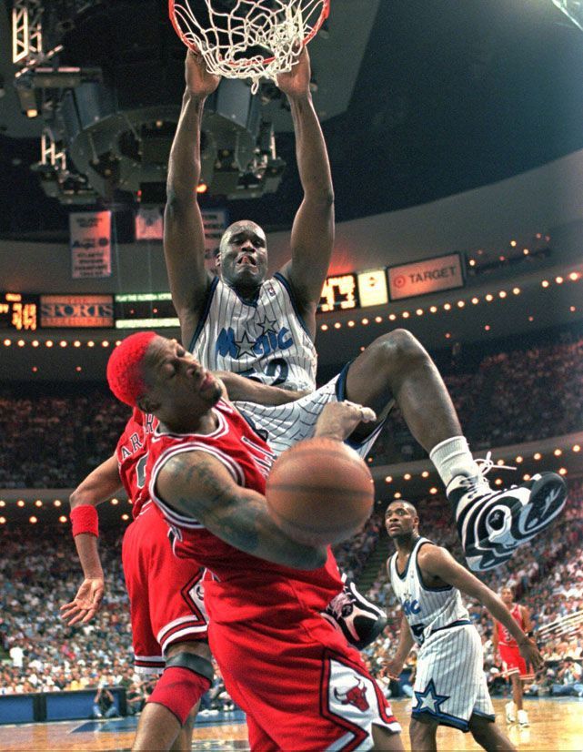 two men playing basketball in front of an audience