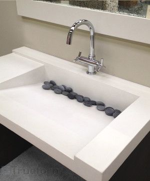 a bathroom sink with rocks on the bottom and a faucet mounted above it